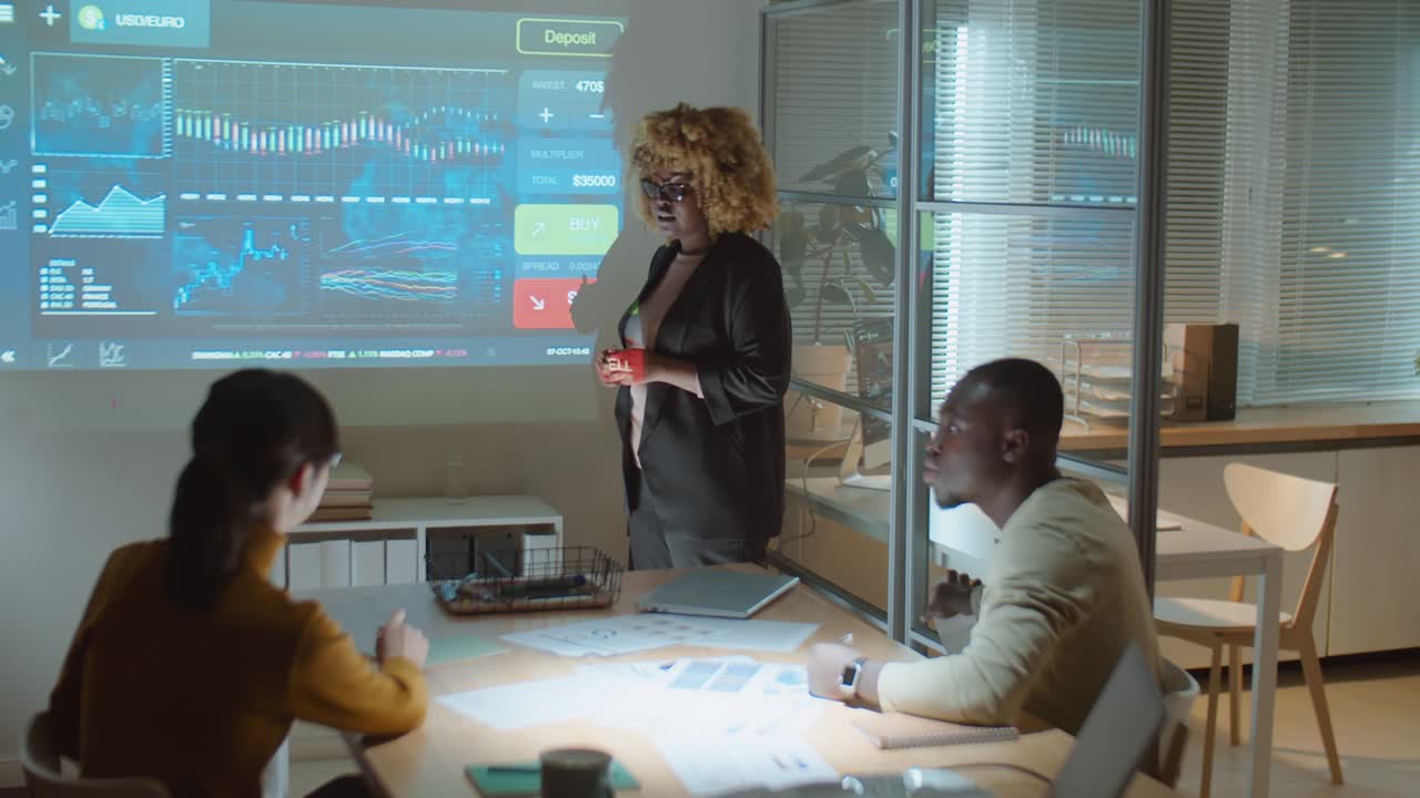 equipo discutiendo gráficos financieros en una reunión de negocios nocturna