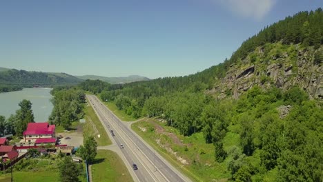 aerial low level flying over the highway the view between the rock and the mountain turquoise river