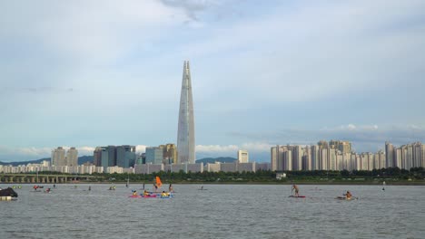 water activities at han river in seoul, south korea with famous lotte tower in background