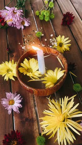 floral arrangement with candle in wooden bowl