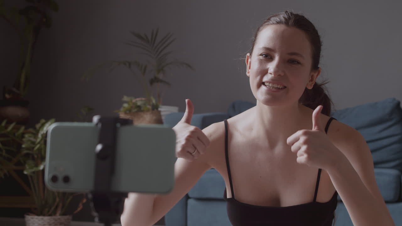 primer plano de una mujer joven y atlética influyente que habla con sus seguidores a través de la cámara de su teléfono inteligente