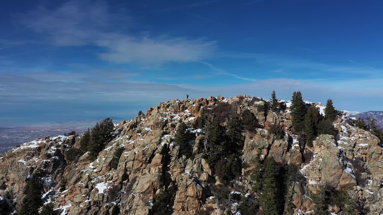 vista aérea del escalador en la cima de la colina sobre el pintoresco valle y el paisaje invernal