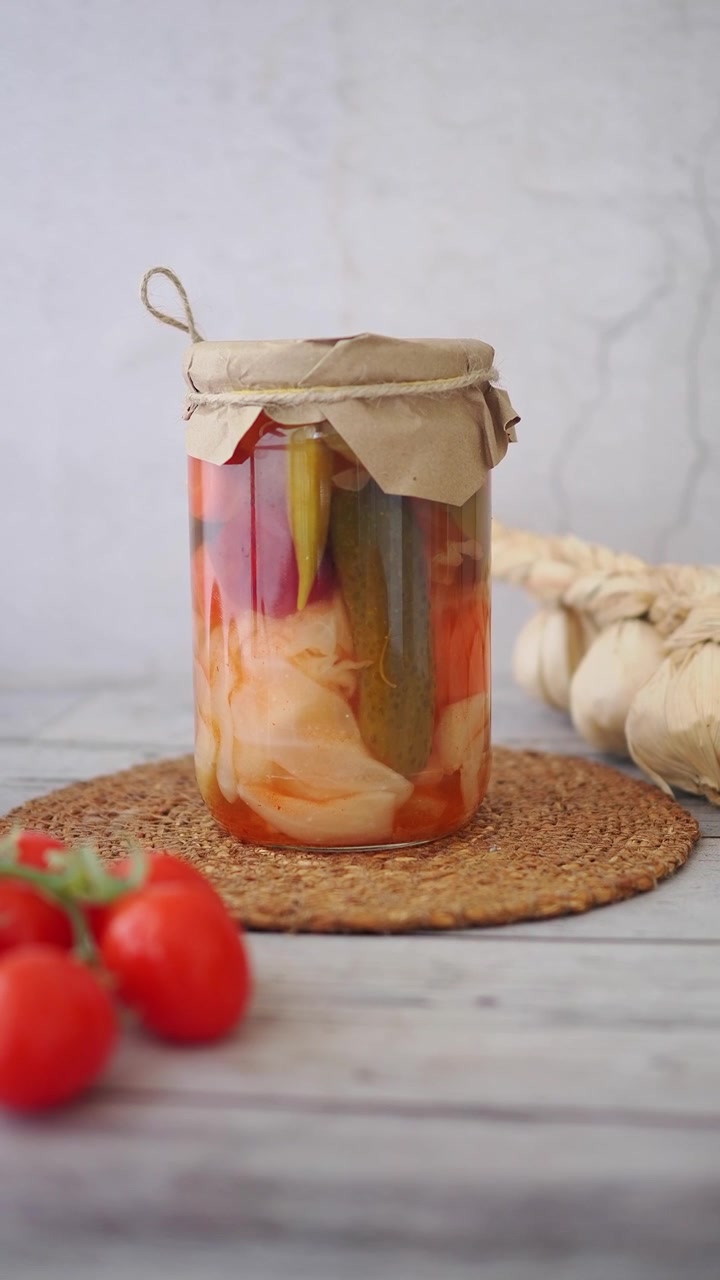 Einmachglas mit hausgemachtem eingelegtem Gemüse auf einem Holztisch