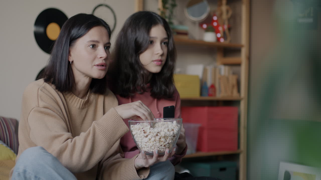 Sisters Enjoying Movie Night with Popcorn