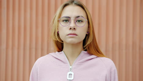 young woman wearing glasses and pink hoodie