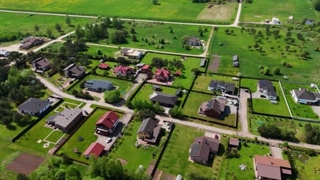 Una-Vista-Aérea-De-Un-Barrio-Suburbano-Con-Césped-Verde-Y-Casas-Modernas-En-Lituania.