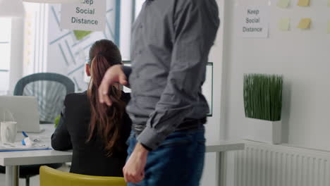 Businessman-with-face-mask-touching-elbow-for-greeting-his-collegue