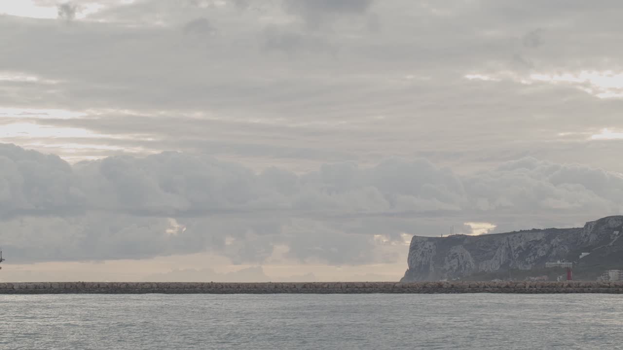 galeón del siglo xvi réplica de andalucia barco que llega al puerto en un hermoso día nublado al amanecer detrás de un rompeolas con la montaña al fondo