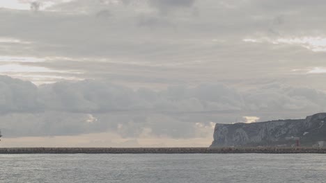 16th century galleon andalucia replica ship arriving at port in a beautiful cloudy day at sunrise behind a breakwater with mountain in the background