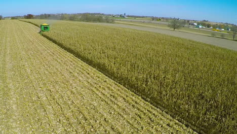 Excellent-aerial-over-a-rural-American-farm-with-corn-combine-harvester-at-work-in-the-fields-1