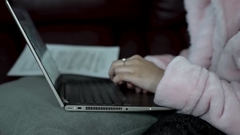 Young-female-student-studies-homework-on-laptop-isolated-in-bedroom-late-at-night