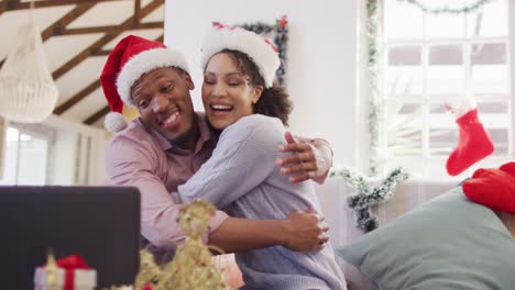 Happy-african-american-couple-with-santa-hats-having-video-call