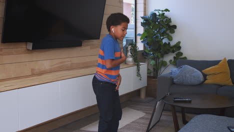 Brother-And-Sister-Having-Fun-Dancing-To-Music-At-Home