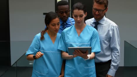 team of doctors discussing over digital tablet