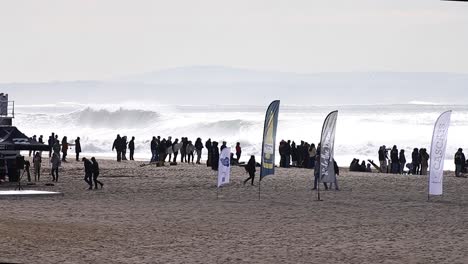 wide view of the beach with big waves in the background at perfect chapter,, also called "capitulo perfeito" in a famous surf spot, carcavelos, cascais