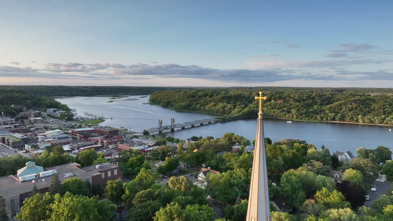 Drone flight past St Michael's church spire and cross, view of St Croix river