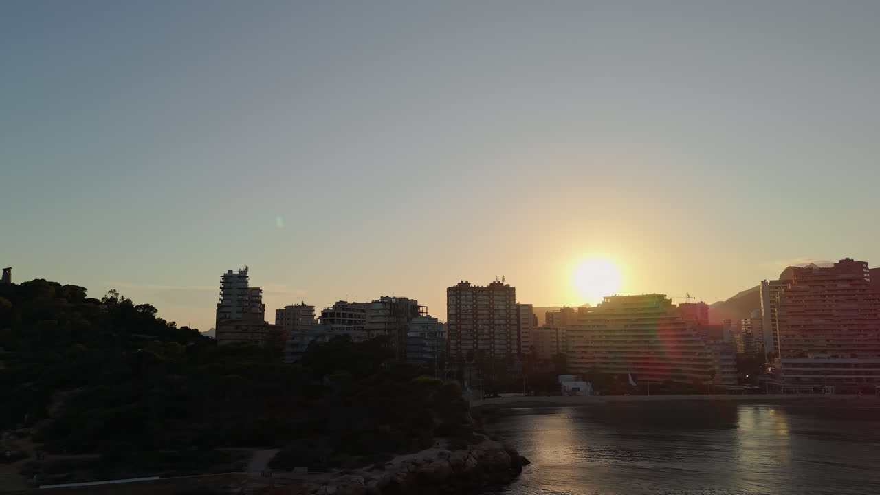 Vista Aérea do Horizonte de Cidade Costeira ao Pôr do Sol com Oceano e Praia