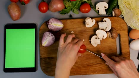 woman cutting vegatables on the chopping board in the kitchen.