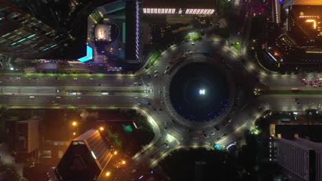 night illuminated jakarta city downtown traffic street circle fountain aerial topdown panorama 4k indonesia