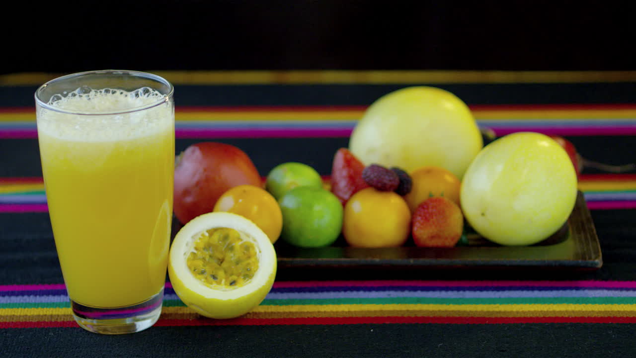 frutas frescas y un vaso de jugo de maracuyá