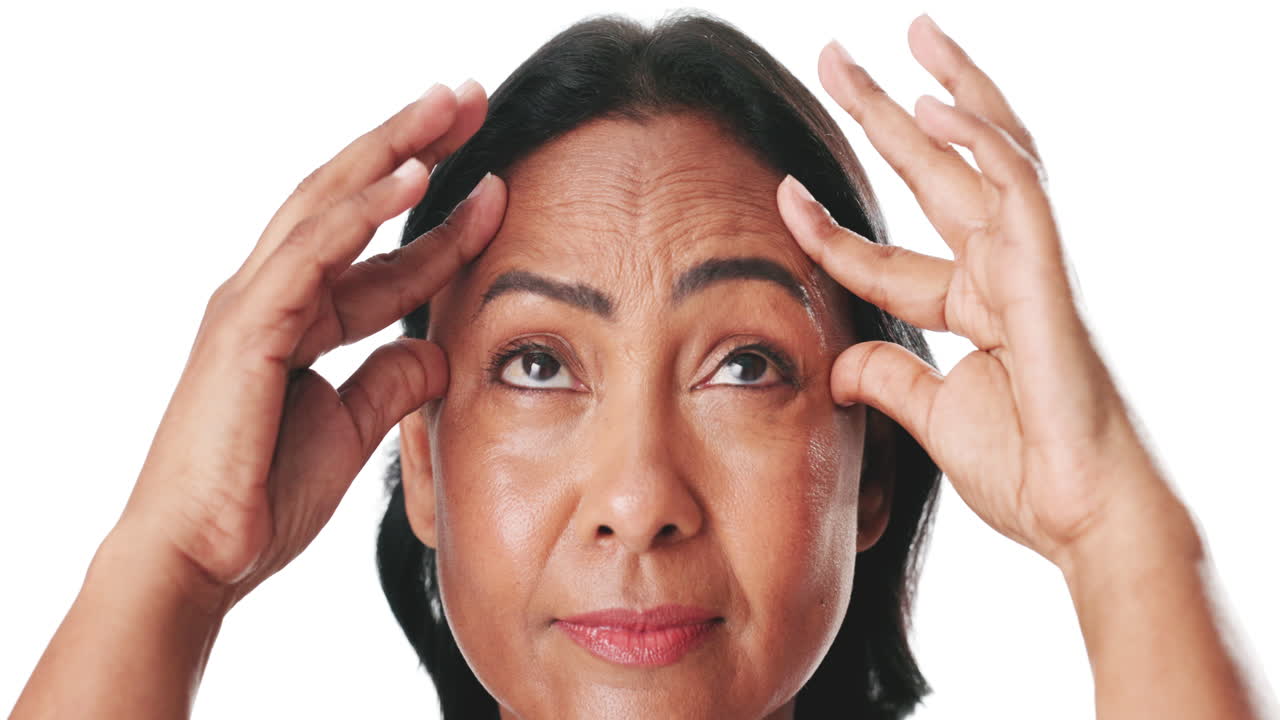 Mature Woman Examining Wrinkles on Her Forehead and Temples