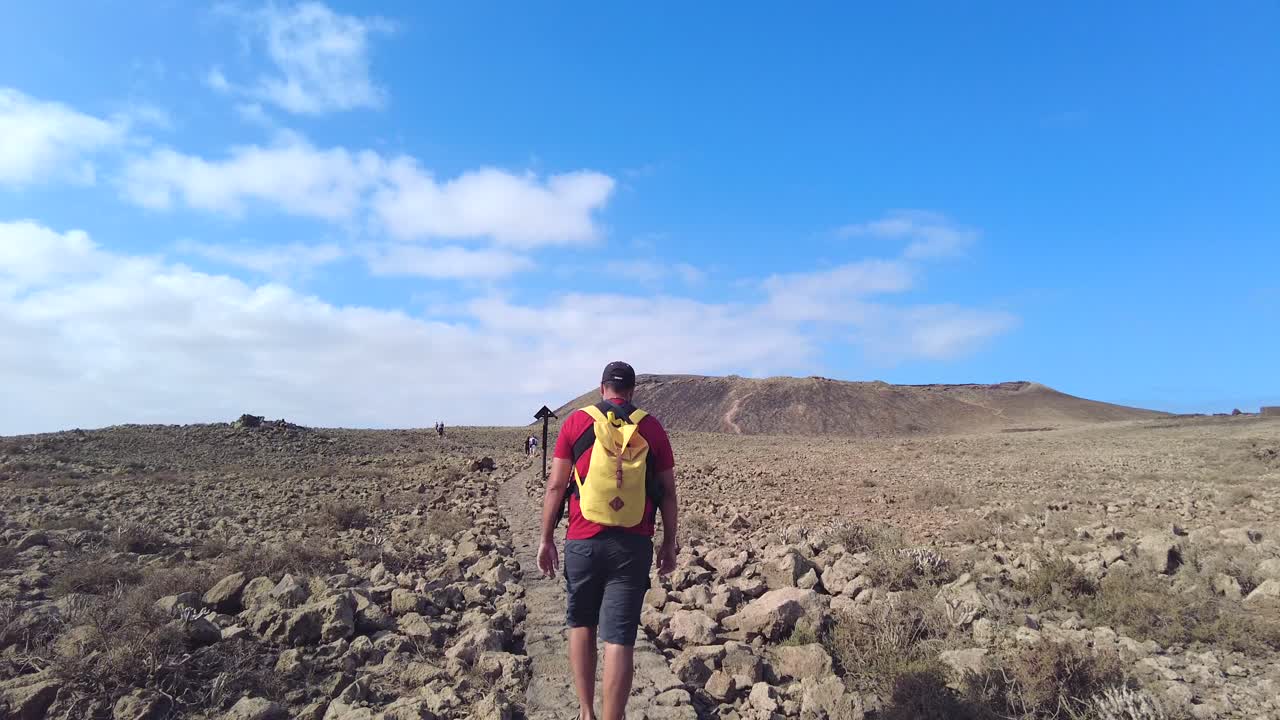 Un hombre caminando hacia un volcán