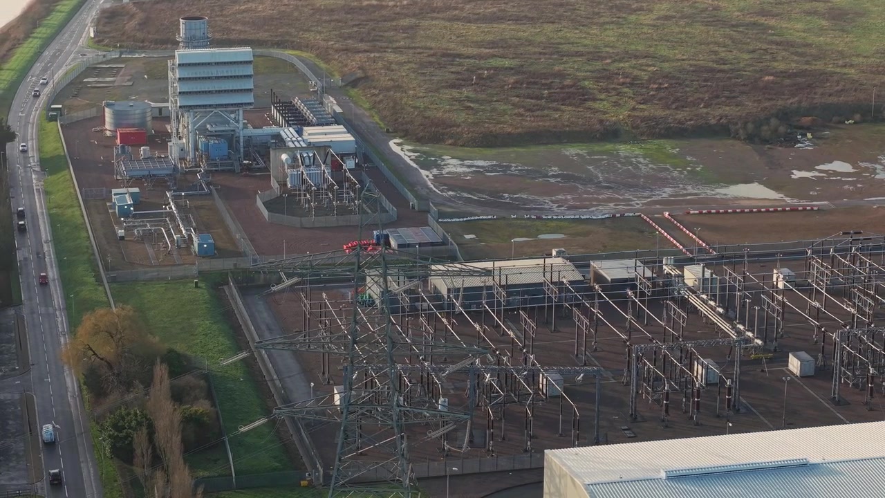 Drohnenaufnahme aus der Vogelperspektive der Schornsteine der Spalding Energieanlage und des Stromübertragungsnetzes.