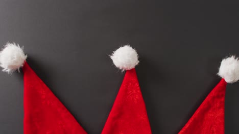 video of close up of santa hats on gray background