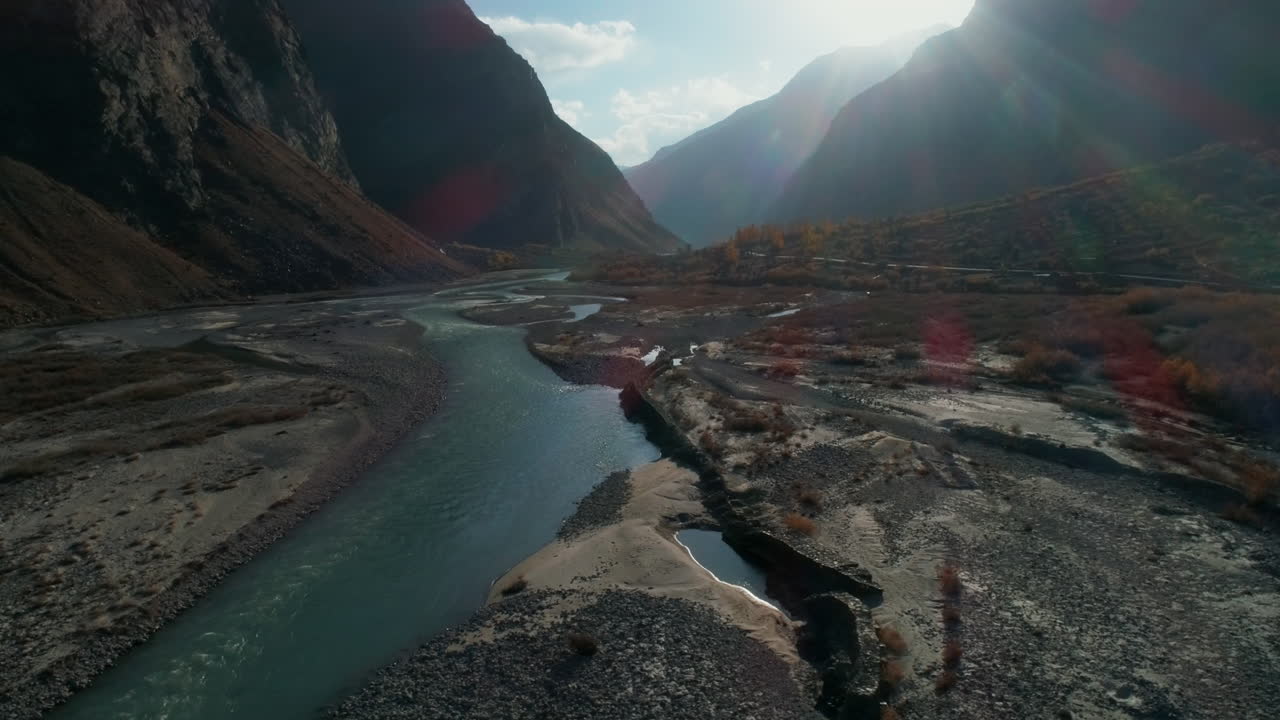 Drone che vola con movimento circolare sopra una splendida valle di montagna. Paesaggio serale autunnale da sogno dell'Himalaya con ruscelli di fiume dall'acqua limpida