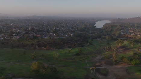 Aerial-view-of-Cowles-Mountain-in-San-Diego-California-on-a-cloudy-mist-day,-Lake-Murray-in-view-tracking-wide-shot-west-coast