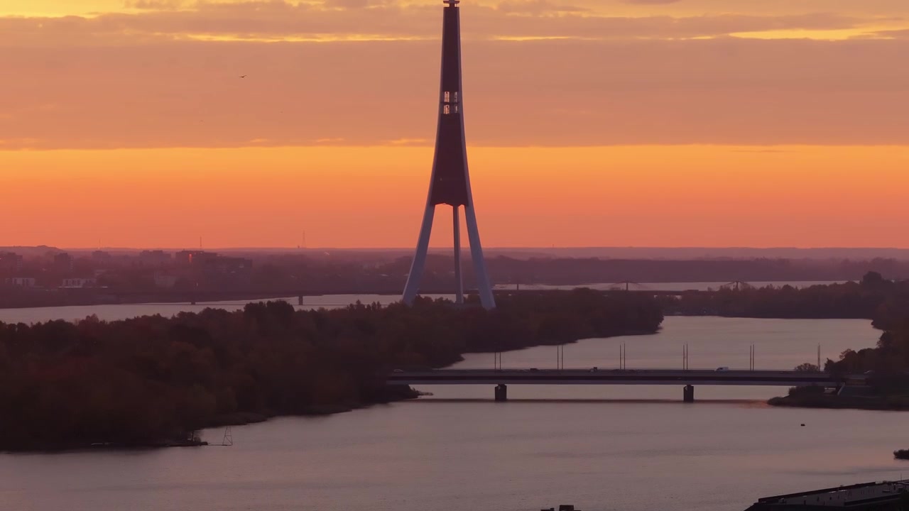 Tramonto sereno mette in risalto una torre - il suo riflesso su acque calme, Riga, Lettonia