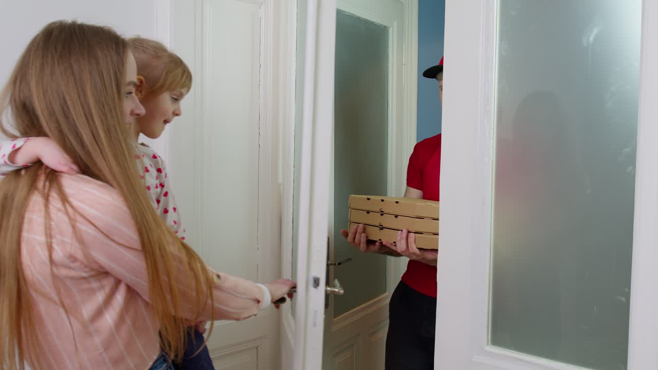 피자 상자를 가진 배달사가 종을 치고, 아이를 가진 여자가 문을 열고, 주문에 현금을 지불합니다.