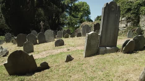 Flying-Over-Headstones-At-The-Old-Ruin-Cemetery-Of-Glendalough,-County-Of-Wicklow-In-Ireland