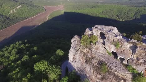 luftaufnahme einer felsigen bergformation mit höhlen und wald