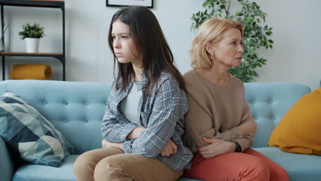 teenage daughter and mother arguing on the couch