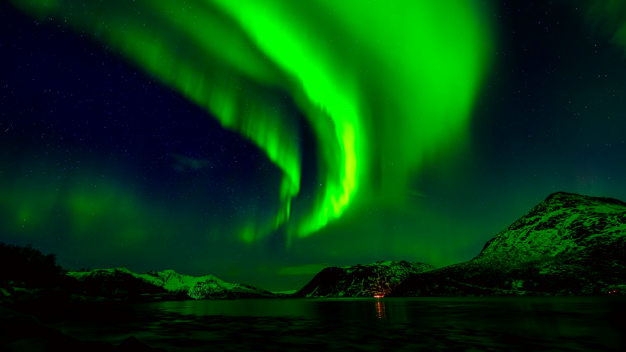 Stunning time-lapse of the Aurora Borealis dancing over the fjord and peak in Grotfjord near Tromso, Northern Norway, during a clear Arctic winter night