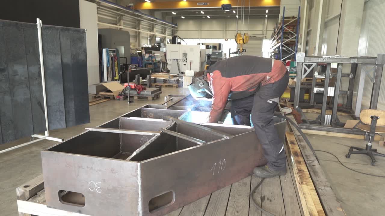 Hombre en un entorno de fabricación industrial soldando y trabajando con acero.