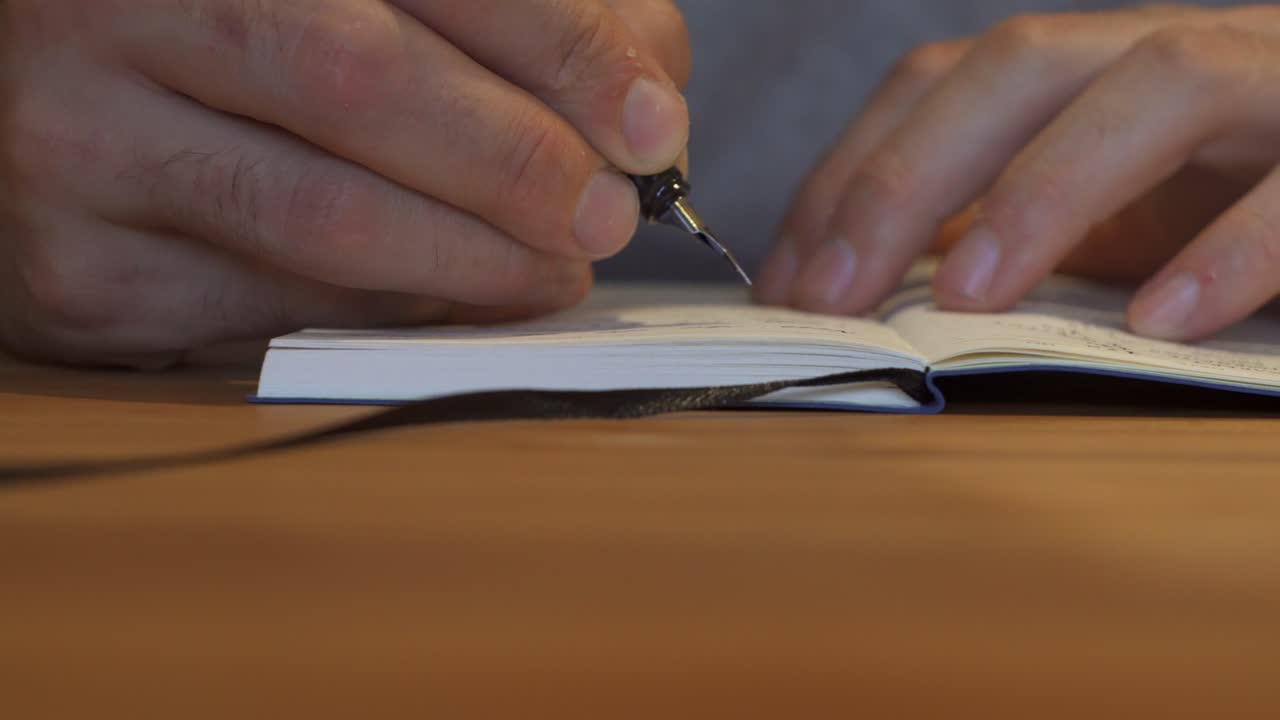 Man finished writing in notebook and closing it up