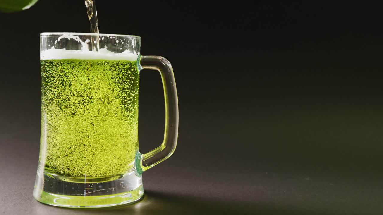 video del día de san patricio un vaso de cerveza verde con espacio de copia sobre un fondo gris.