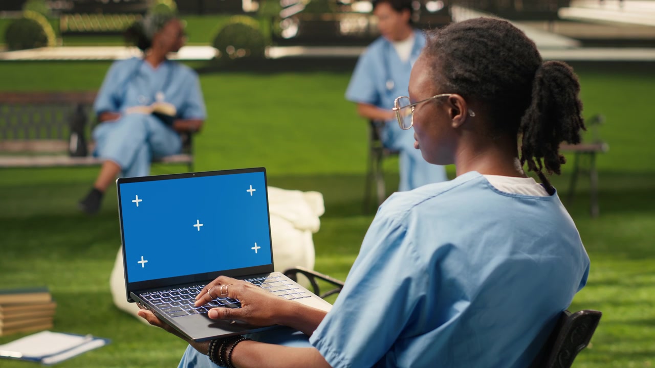 Blue screen chroma key on laptop held by black medical student
