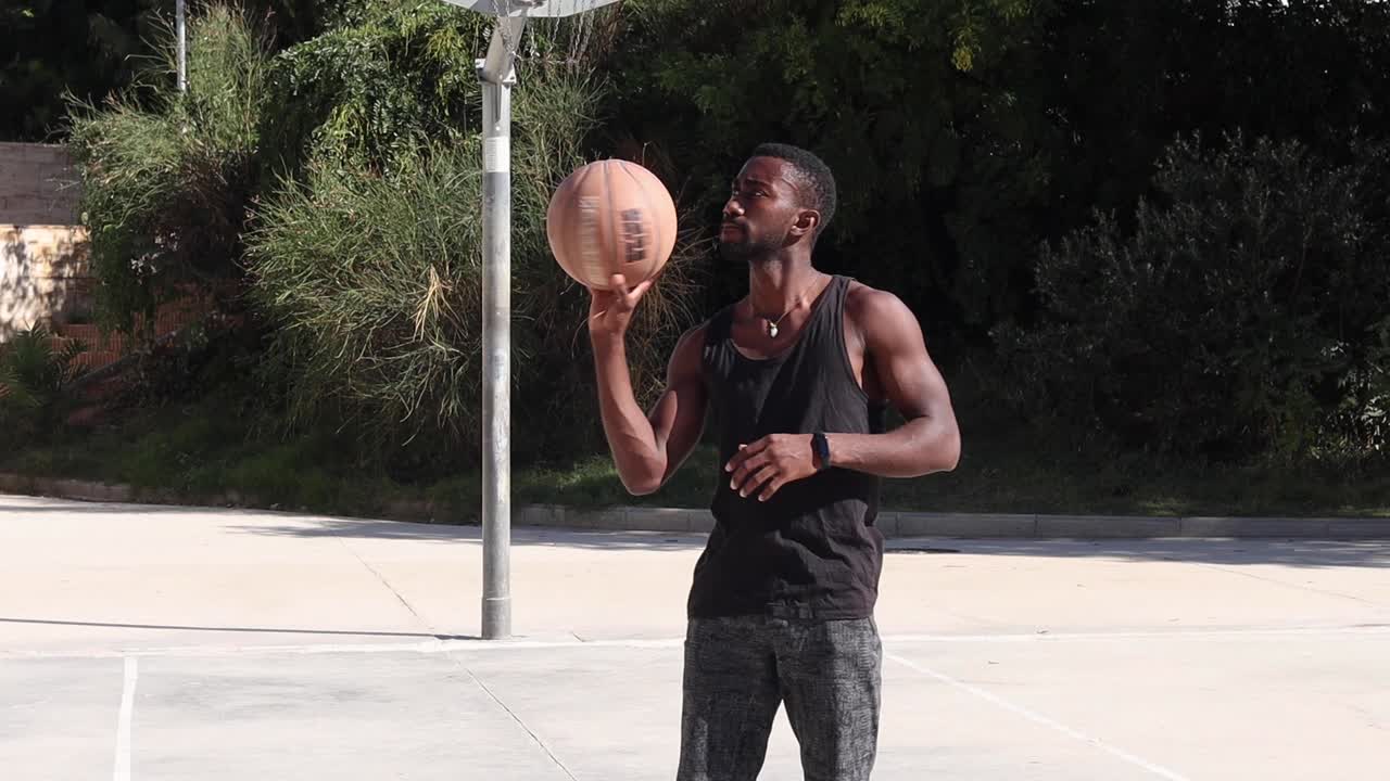 Black man spinning basketball on finger