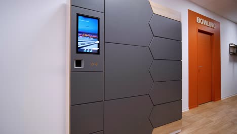 slow establishing shot of an electronic locker at reception of a bowling alley