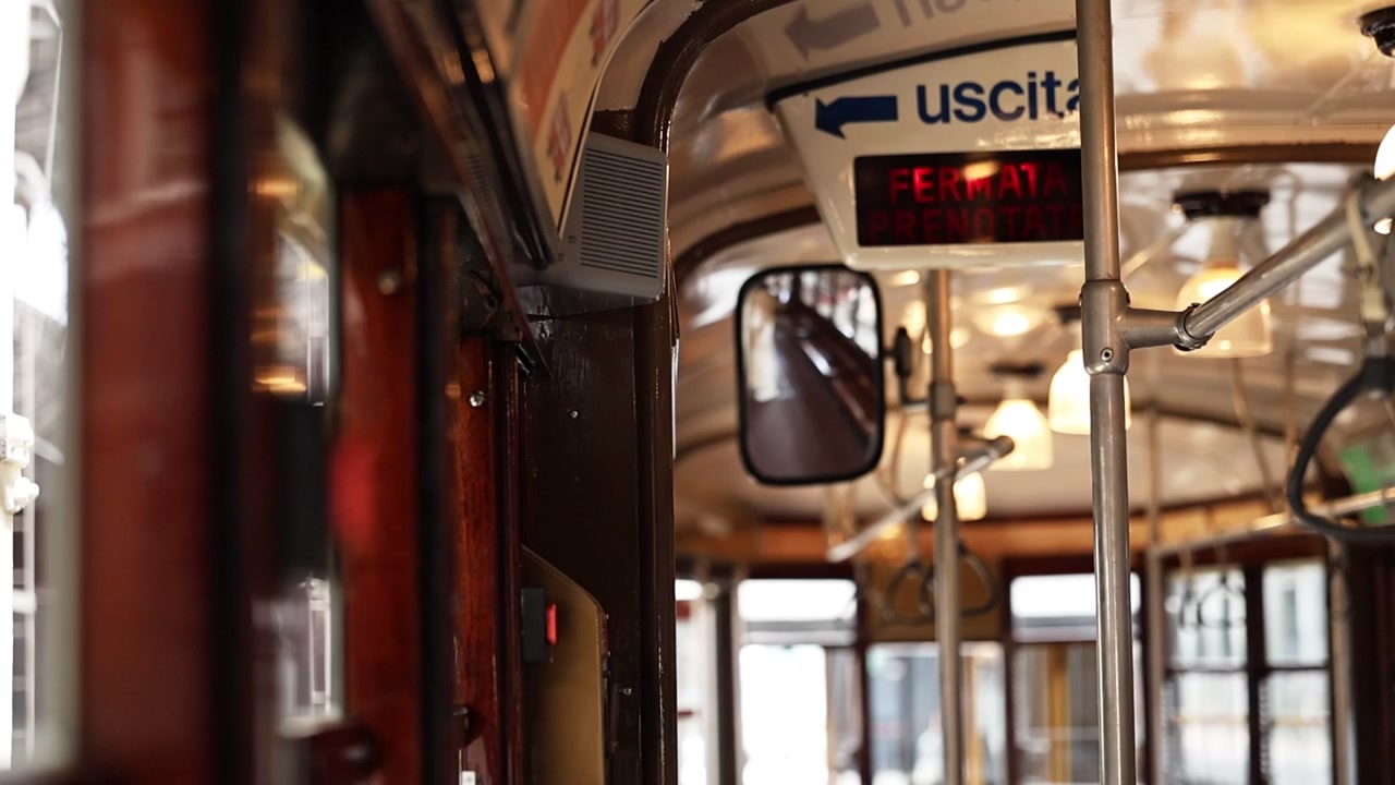 Passeggero che preme il pulsante di stop su un tram d'epoca