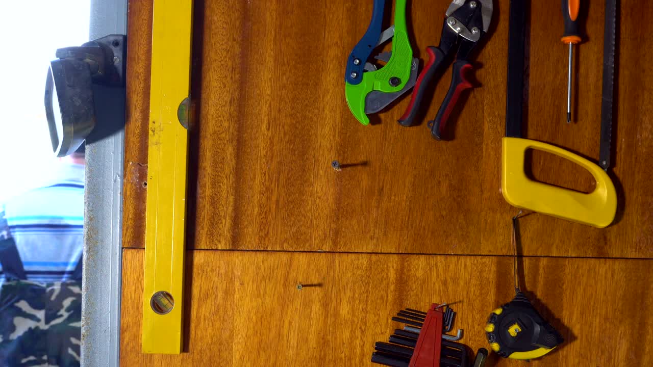 un anciano saca una herramienta de trabajo del garaje.