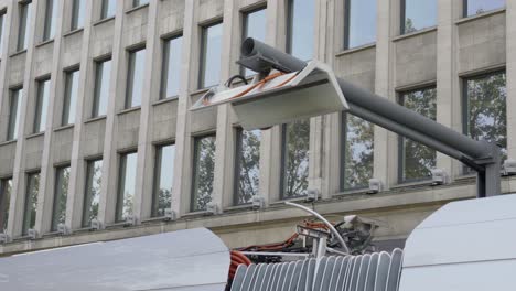 close up of a lowering pantograph and electric bus departing