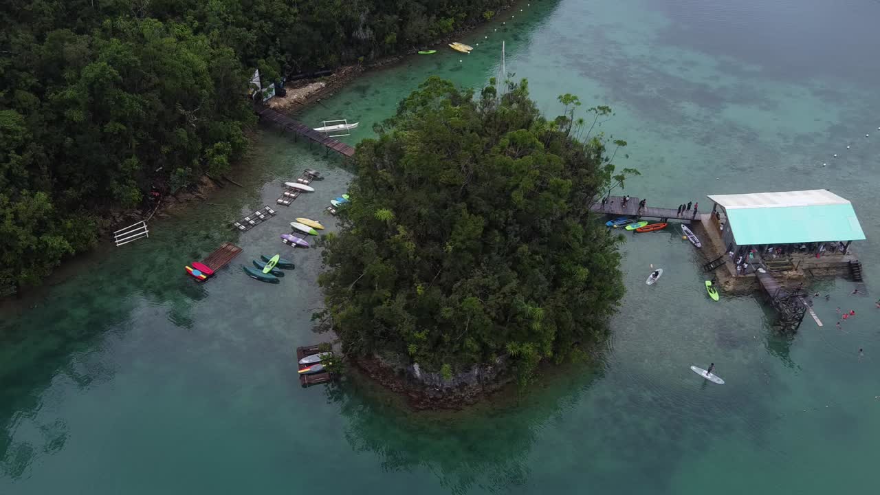 personas haciendo surf y kayak en la famosa isla de siargao rodeada de selva tropical, filipinas