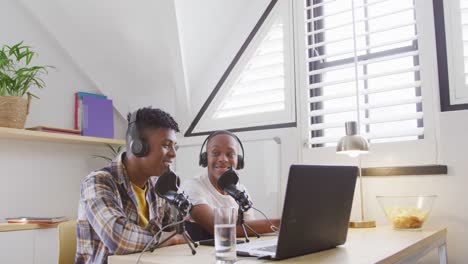 Happy-african-american-male-teenage-friends-using-laptop-and-making-vlog,-slow-motion