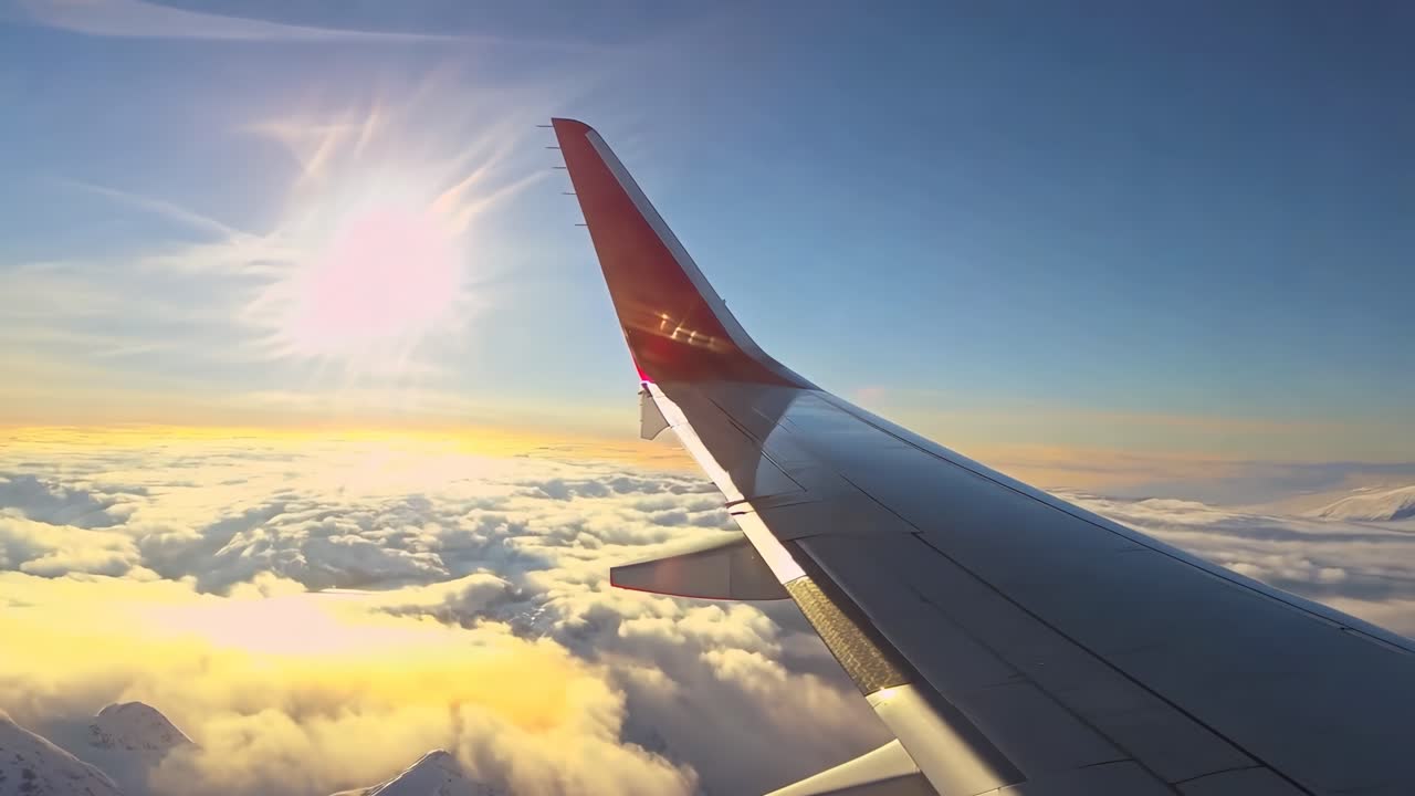 Video aereo di un'ala di aeroplano sopra le nuvole all'alba, ripreso dall'angolazione del finestrino di un passeggero
