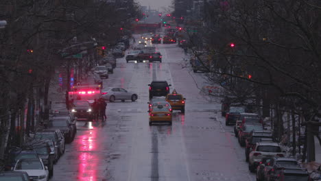 slow-motion of new york traffic with an ambulance on a wet manhattan main street