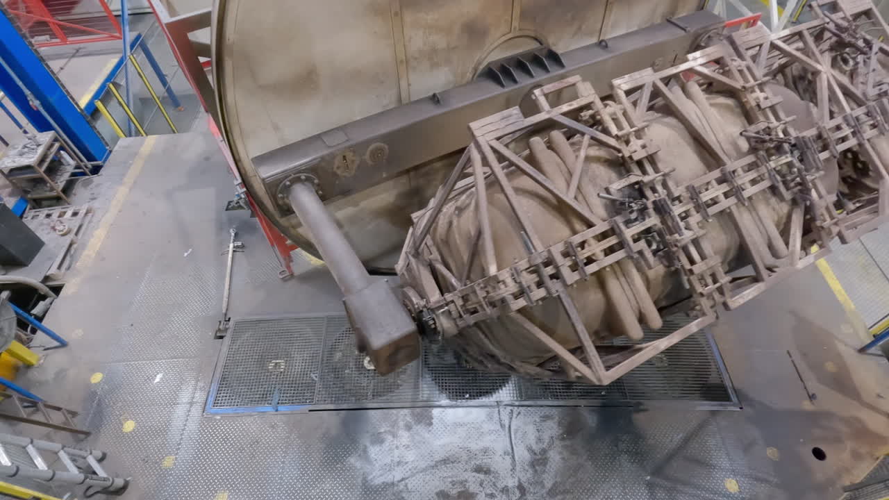 큰 녹슨 야금 산업 기계의 상단 샷은 가열실에서 냉각 팬으로 회전하고, 재사용 및 재활용 플라스틱을 사용하는 회전성형 프로세스입니다.